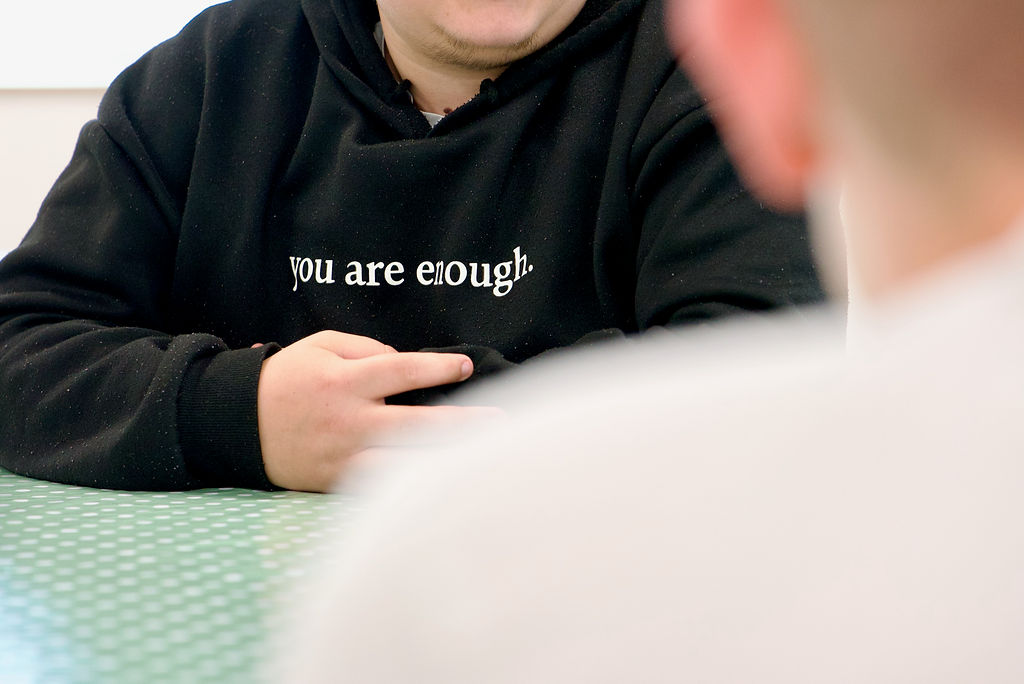 Photo of a person in a hoody saying "you are enough"